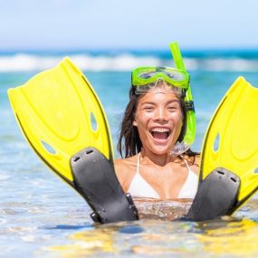 femme avec des palmes dans l'eau sur la plage